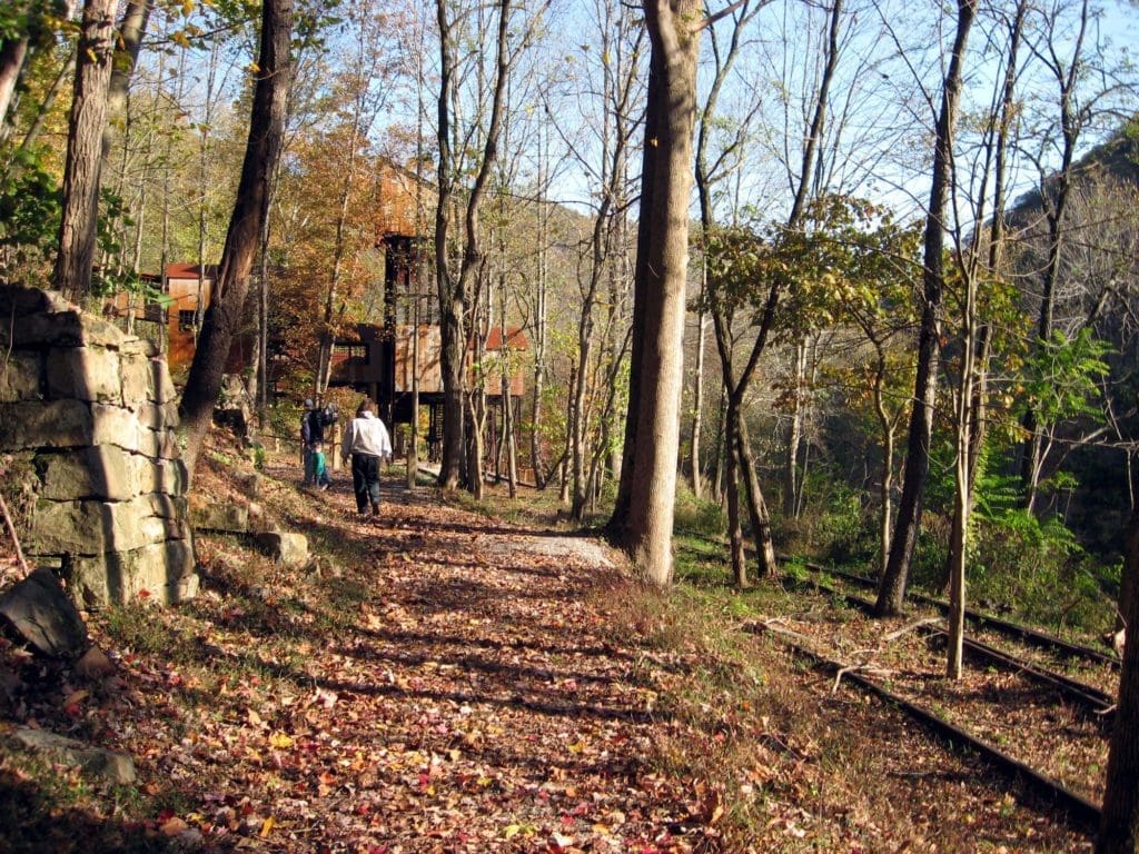 Hikers walking on a trail towards an old coal tipple